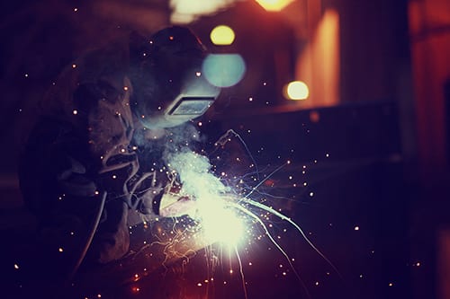 photo of a welder at work with sparks flying around him